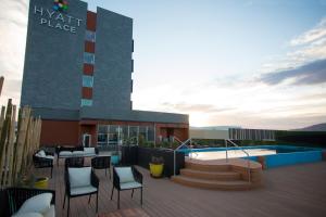 a resort with a pool and chairs and a building at Hyatt Place Saltillo in Saltillo