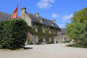 a large stone building with a flag on it at Domaine du Haul - Gîte Le Pressoir in Catteville