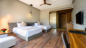 a hotel room with two beds and a television at Aria Resort & Spa - Pure Veg in Nashik