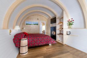 - une chambre avec un lit et une couverture rouge dans l'établissement Glamping Villaggio Parco Dei Castagni 4 stelle, à Montecreto