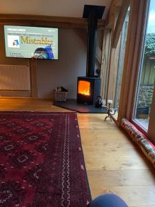 a living room with a fireplace and a red rug at Dartmoor National Park- Romantic Cottage in Lustleigh