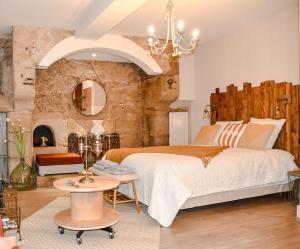 a bedroom with a large bed and a stone wall at La Chaumière, centre historique, fibre, ESS, rez-de-chaussée, BedinShop in Romans-sur-Isère