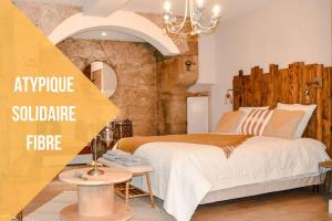 a bedroom with a large bed and a chandelier at La Chaumière, centre historique, fibre, ESS, rez-de-chaussée, BedinShop in Romans-sur-Isère