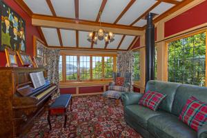 a living room with a couch and a piano at Woodroyd Estate holiday sanctuary in Island Bay