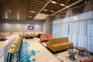 a lobby with a waiting area with chairs and tables at Hyatt Place Saltillo in Saltillo
