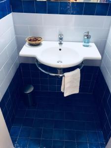 a white sink in a blue tiled bathroom at Sara Apartment, Comfort and lateral sea view in Riomaggiore