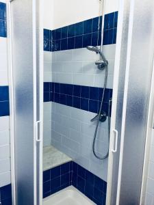 a blue tiled bathroom with a shower with a tub at Sara Apartment, Comfort and lateral sea view in Riomaggiore