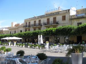 eine Terrasse mit Tischen und Stühlen vor einem Gebäude in der Unterkunft Terrasini Siracasa in Terrasini