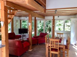 a living room with red couches and a table at Haus Janina in Rieste