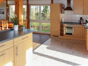 uma cozinha com armários de madeira e um forno com placa de fogão em Haus Janina em Rieste