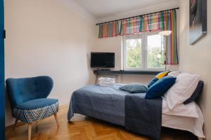 ワルシャワにあるKrasinskiego 8 - Plac Wilsonaのベッドルーム1室(ベッド1台、椅子、窓付)