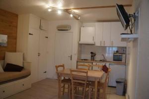 a kitchen and dining room with a table and chairs at T2 Immeuble Chanteclerc 6 personnes 37m2 PRALOUP 1600 in Uvernet-Fours