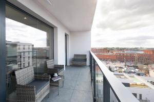 a balcony with chairs and a view of a city at Manufaktura SKYLINE by PinPoint in Łódź