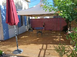 a white umbrella on a patio with a table and chairs at terre et mer in Sainte-Ramée