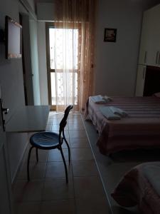 a bedroom with a chair and a bed and a window at Hotel Tuo Mare in Silvi Marina