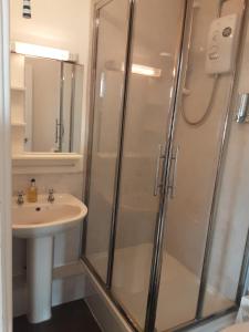 W łazience znajduje się prysznic i umywalka. w obiekcie Valentine Guest House w mieście Weymouth