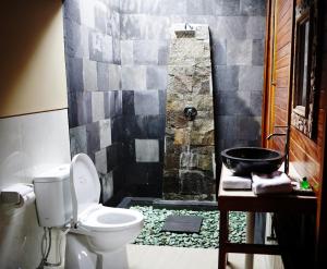 een badkamer met een douche, een toilet en een wastafel bij Nadya Homestay in Munduk