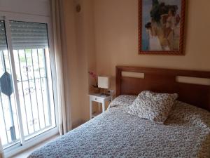 ein Schlafzimmer mit einem Bett und einem Fenster in der Unterkunft AME447 Chalet con piscina privada 9x5m y jardín vallado in Les tres Cales + 43 Fotos