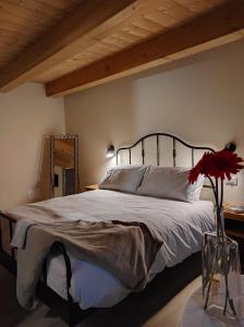 a bedroom with a large bed and a vase with flowers at Le Farfalle di Armeno in Armeno