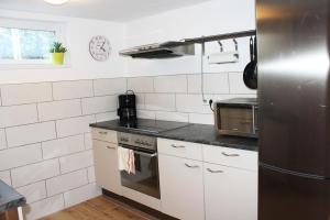 a kitchen with white cabinets and a stainless steel refrigerator at Ferienwohnung Landlust Wolfenbüttel in Klein Denkte