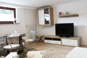 a living room with a flat screen tv and a table at Ferienwohnung Landlust Wolfenbüttel in Klein Denkte