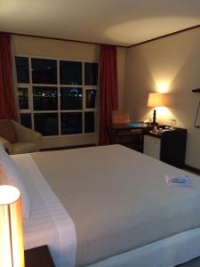 Cette chambre comprend un grand lit et une fenêtre. dans l'établissement Cebu Dulcinea Hotel and Suites-MACTAN AIRPORT HOTEL, à Mactan