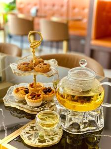 una mesa con una bandeja de magdalenas y una olla de miel en Topnorth Hotel Maesai, en Mae Sai