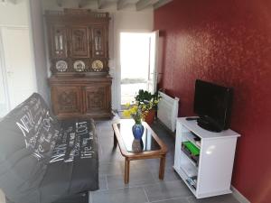 a living room with a couch and a tv at Le Gîte Mayann in Saint-Pierre-en-Port
