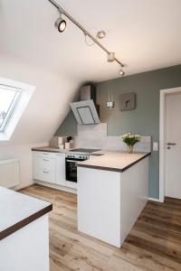 HolzmadenにあるFerienwohnung Albblickのキッチン(白いキャビネット、白いカウンタートップ付)