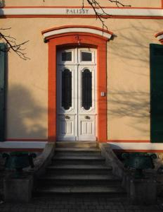 a white door on a building with stairs in front at Les Villas de la Ville d'Hiver Palissy in Arcachon