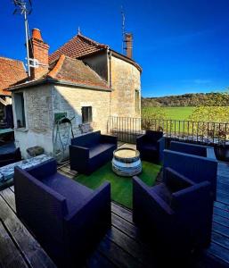 eine Terrasse mit blauen Sofas auf einer Holzterrasse in der Unterkunft Coté-Serein La Privilège de la Tour Madame in Noyers-sur-Serein