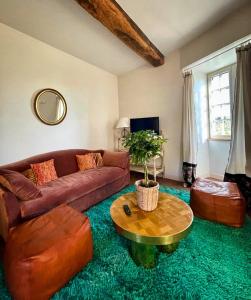 een woonkamer met een bruine bank en een tafel bij Coté-Serein La Privilège de la Tour Madame in Noyers-sur-Serein