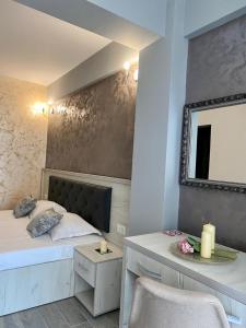 a bedroom with a bed and a mirror and a chair at Ida Beach in Mamaia Nord