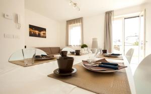 a dining room with a table with plates and chairs at Urban Homy Gorizia in Gorizia