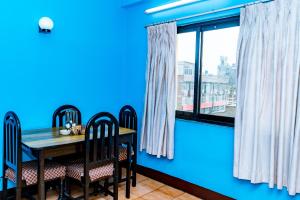 帕坦KBB Hotel and Apartments Hosted by Hostmandu的一间拥有蓝色墙壁和桌椅的用餐室