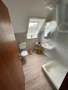 ein Bad mit einem WC, einem Waschbecken und einem Fenster in der Unterkunft Haus Corinna in Büsum