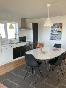 a kitchen and dining room with a table and chairs at Surfers Paradise Apartments in Hvide Sande