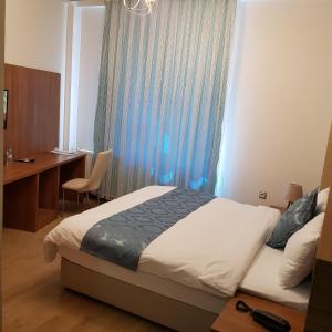 - une chambre avec un lit, un bureau et une fenêtre dans l'établissement ASİL OTEL, à Şanlıurfa
