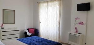 een slaapkamer met een bed, een stoel en een spiegel bij Casa Athena in Sorrento