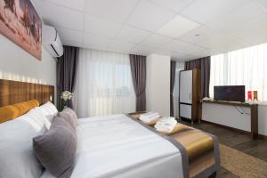 a hotel room with a large bed and a television at River Elite Hotel Spa in Antalya