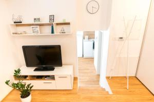 una sala de estar con TV en un armario blanco en Apartment ALMA - to travel is to live en Celje