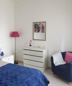 een slaapkamer met een bed, een dressoir en een stoel bij Casa Athena in Sorrento