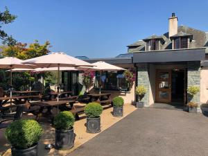 ein Restaurant mit Holztischen und Sonnenschirmen in der Unterkunft The Mary Mount Hotel in Keswick
