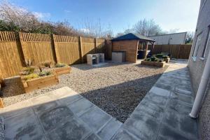 einen Hinterhof mit einem Holzzaun und einem Pavillon in der Unterkunft Rhos Walia,near Snowdonia,Hot tub in Caernarfon
