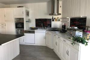 cocina con armarios blancos y fogones en Grand appartement 2 minutes plage et commerces, en Saint-Cyprien