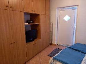 a bedroom with a bed and a cabinet with a television at Studio Ana in Selce
