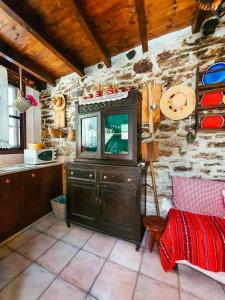 a kitchen with a tv in a stone wall at Stratos ArtDeco House in Kalavasos