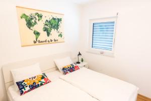 Cette chambre dispose d'un lit blanc et d'une carte murale. dans l'établissement Apartment ALMA - to travel is to live, à Celje