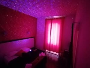 a purple room with a bed and a window with pink lights at Chroma Exy - Chroma Italy in Rome