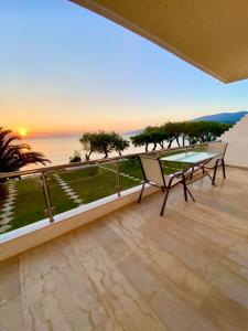 a balcony with a table and a view of the ocean at NanSea Apartment in Loutra Oraias Elenis 